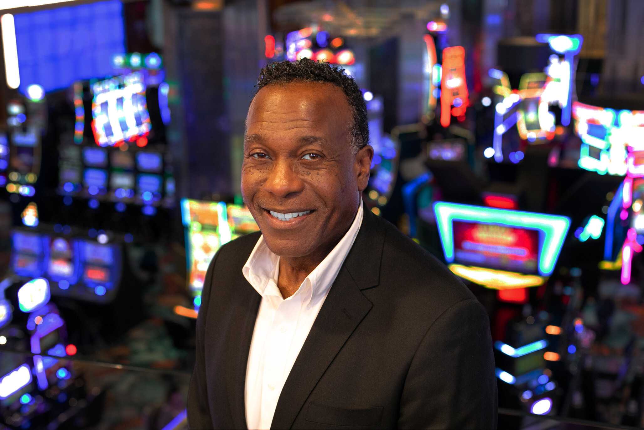 Headshot of Charles Daniel Jr., Vice President of Human Resources at Jamul Casino, smiling in professional attire with vibrant casino lights in the background.